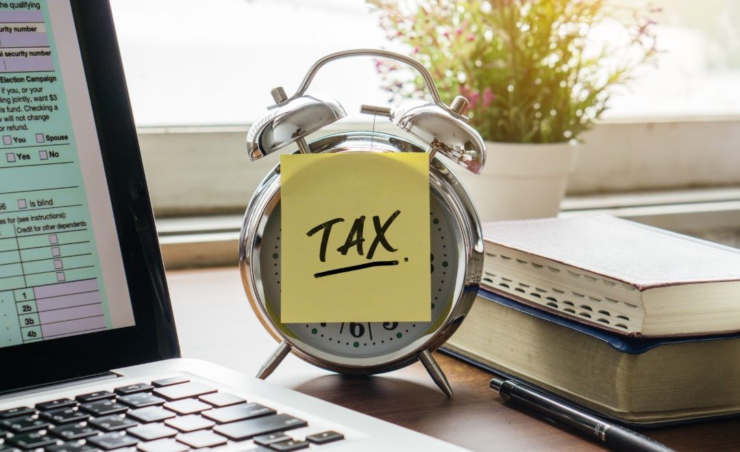 Tax documents and a calculator on a desk, symbolizing tax season planning and investment strategies.